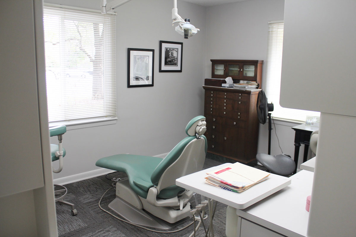 Dental office interior with a chair, desk, and equipment.