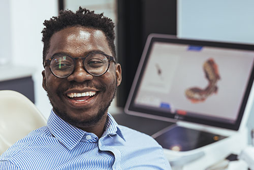 A man in a professional setting, smiling and looking directly at the camera.