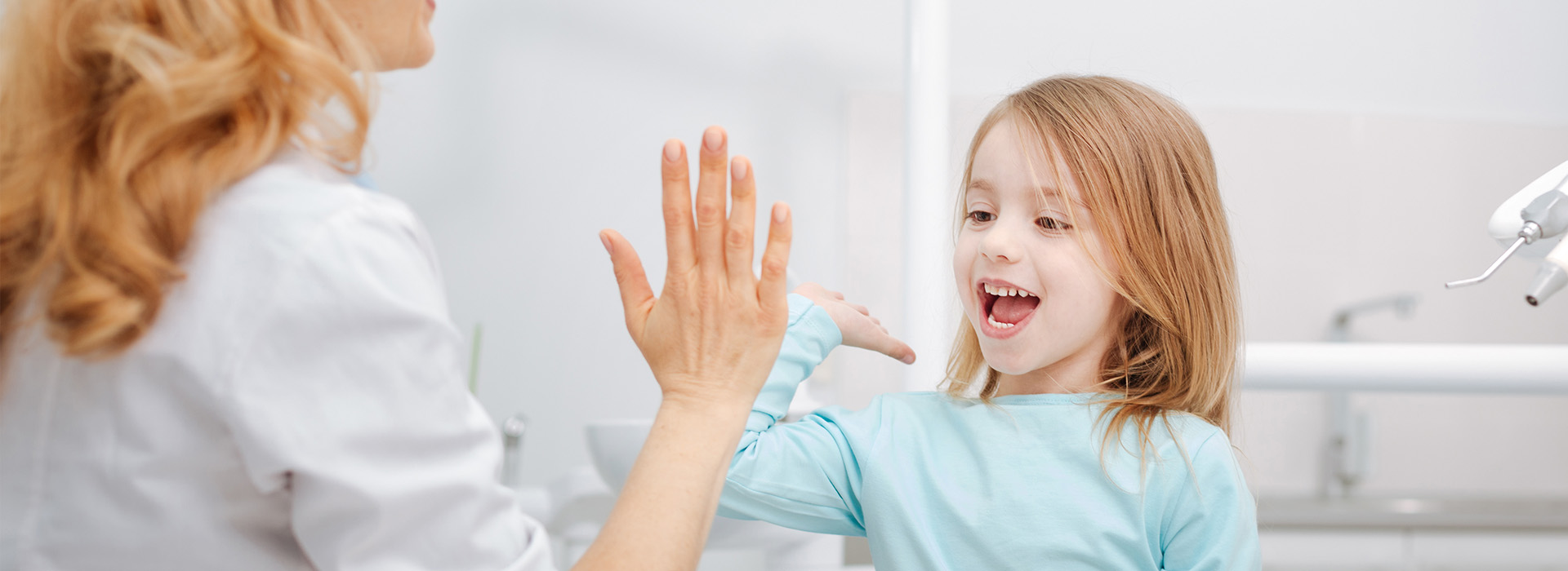 The image shows a woman and a young girl in a bathroom setting, with the woman reaching out to touch the child s face.